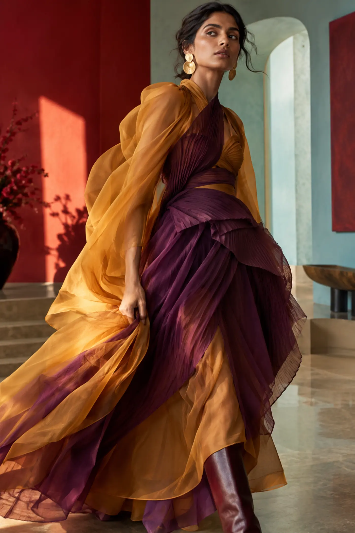 Model in sculptural saffron and plum evening layers